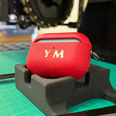 Custom foil stamping on PU AirPods case – digital embossing on synthetic leather product